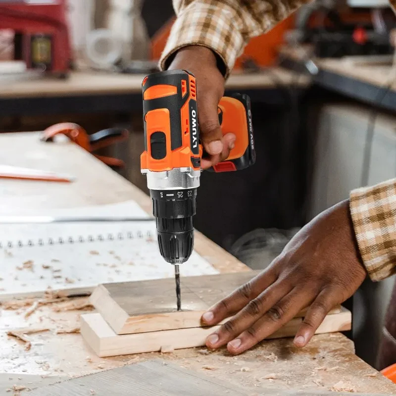Person using an orange cordless drill on wood.