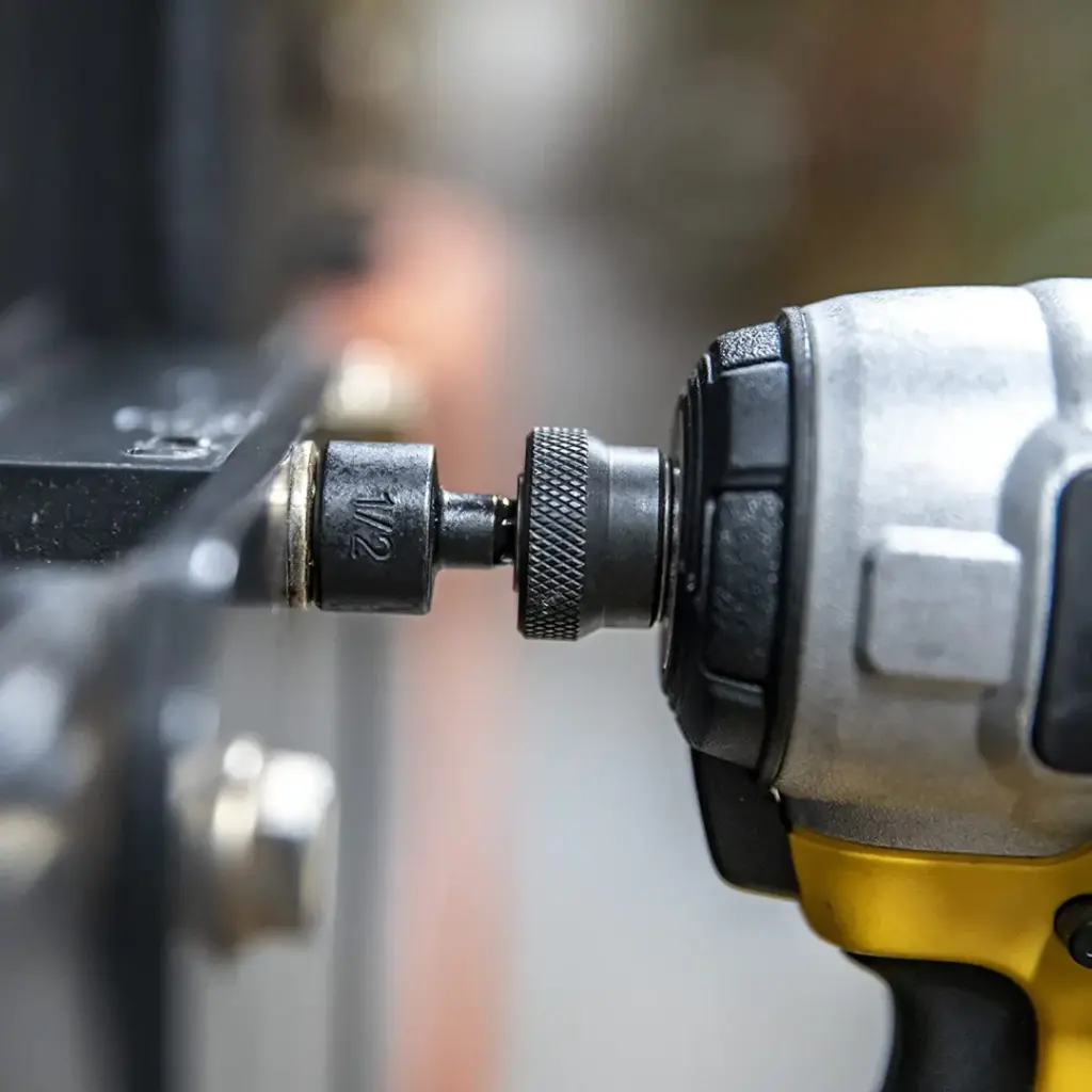 Close-up of a power drill tightening a bolt.